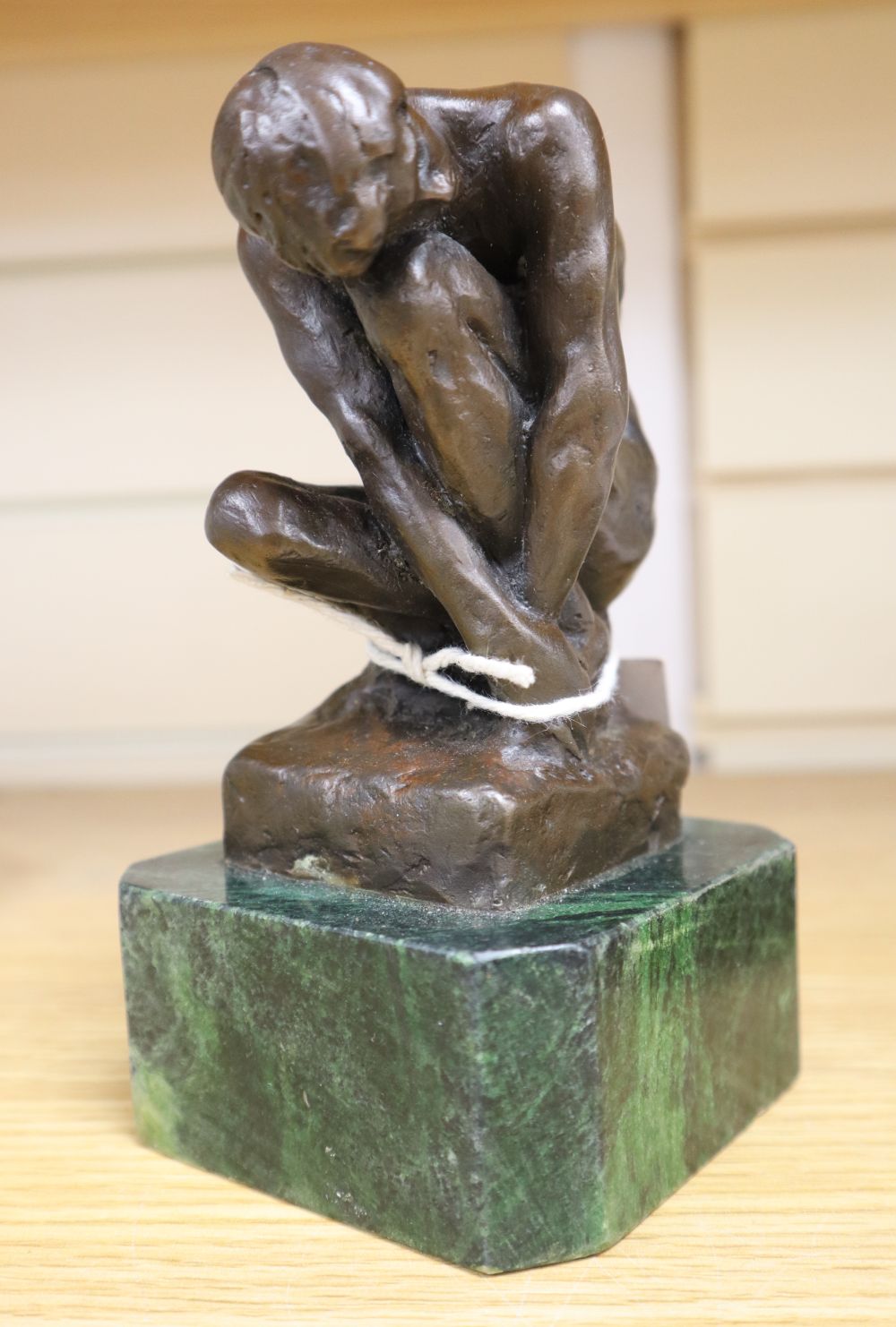 After A. Rodin. A bronze crouching male nude, height 16cm